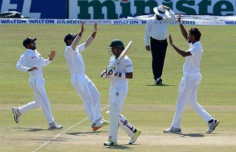 Sri Lankan cricketer Suranga Lakmal (R) celebrates with teammates after he dismissed Bangladesh batsman Soumya Sarkar (2L) during the third day of the opening Test cricket match between Sri Lanka and Bangladesh at The Galle International Cricket Stadium i