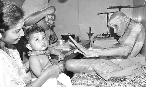 Sri Shivakumara Swamiji applies holy ash(vibhuti) to one of his young devotees during his early morning ‘Shivapooja’ at Siddaganga Mutt in Tumakuru district on Friday | T H Suresh