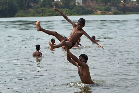 Children enjoying bath in Koyna river on a hot day in Karad Maharashtra on Saturday.(Photo | PTI)