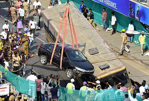 A crane lifting the MTC bus and a car that were stuck in the crater on the road that caved-in before Gemini flyover, on Mount Road, on Sunday | Ashwin Prasath