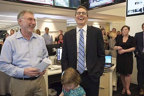 Washington Post editor Martin Baron, left, joins the paper's staff in congratulating David Fahrenthold, center, upon learning that he won the Pulitzer Prize for National Reporting, for dogged reporting of Donald Trump's philanthropy, in the newsroom of th