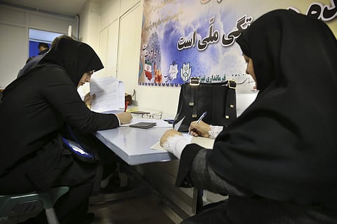 Hopeful candidates for the elections fill out official documents to register in Tehran. (File photo | AP)