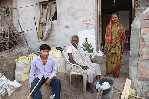 Land fraud victim farmer Laxman Uike with son and wife at their house in Satnur village in MP's Chhindwara district. (EPS)