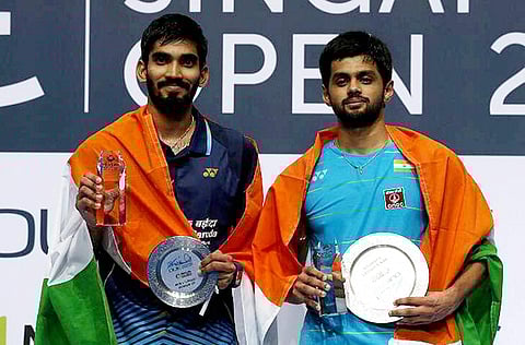 Singapore Open men's singles champion B Sai Praneeth and runner-up Kidambi Srikanth both from India pose with their tropies in Singapore on Sunday. | PTI