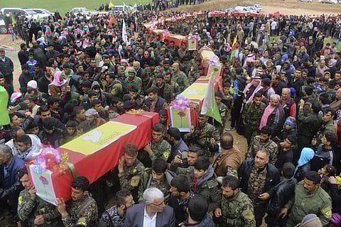 This photo provided by Hawar News Agency, a Kurdish-run news agency, which has been authenticated based on its contents and other AP reporting, shows fighters from the predominantly-Kurdish Syrian Democratic Forces carrying the coffins of their comrades,