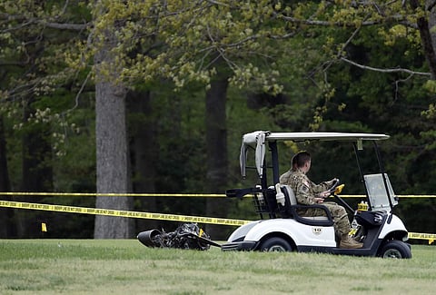 Investigators examine debris that fell on the Breton Bay Golf and Country Club after an Army UH-60 helicopter from Fort Belvoir, Va., crashed, Monday, April 17, 2017, in Leonardtown, Md. (AP)