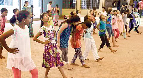Children look on as Krishna Murthy explains Come Come Rain and how air pressure works