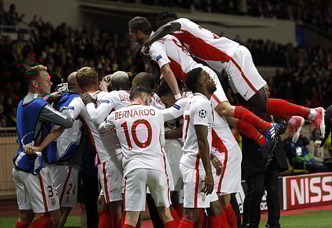 Monaco players celebrate after teammate Valere scored the team's third goal during the Champions League quarterfinal second leg soccer match at the Louis II stadium. | AP