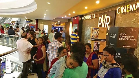 People waiting outside a multiplex bofore the screening of Baahubali-2 in Bengaluru on Thursday night