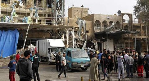 Iraqis inspect the damage on March 21, 2017, the morning after a car bomb attack, in the business district of Hay al-Amel in the west of the capital Baghdad. | AFP
