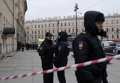 Russian police officers stand guard in a street after a explosion in St. Petersburg's subway, Russia. | AP