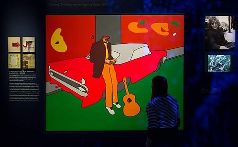 A member of staff poses in front of an artwork inspired by a Syd Barrett photograph during a photocall at the 'The Pink Floyd Exhibition: Their Mortal Remains' at the Victoria and Albert Museum in west London on May 9, 2017. (AFP)