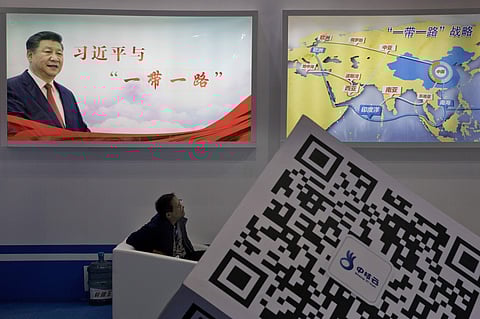 An attendee at a conference looks up near a portrait of Chinese President Xi Jinping with the words 'Xi Jinping and One Belt One Road' and 'One Belt One Road strategy,' in Beijing. (Photo|AP)