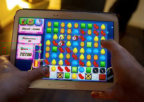 A person plays on his tablet with Candy Crush Saga games developed by British King Digital Entertainment, on March 6, 2014, in Lille, northern France. | AFP