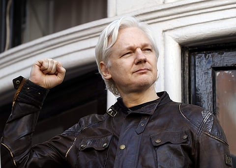 Julian Assange greets supporters outside the Ecuadorian embassy in London. | AP