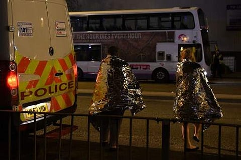 Concert-goers wait to be picked up at the scene of a suspected terrorist attack in Manchester, northwest England. There were scenes of panic as Grande's audience of youthful fans fled the 21,000-capacity venue after what eyewitnesses described as a 'huge