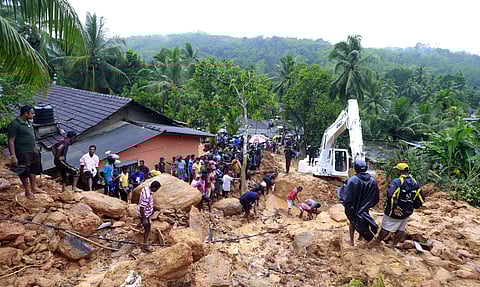 Sri Lankans watch military rescue efforts at the site of a landslide at Bellana village in Kalutara district, Sri Lanka, Friday, May 26, 2017. Mudslides and floods triggered by heavy rains in Sri Lanka killed dozens and left many more missing on Friday. (