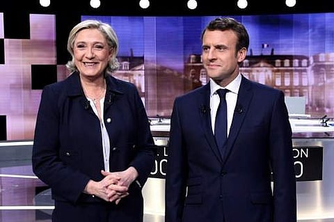 French presidential election candidate for the far-right Front National (FN) party, Marine Le Pen (L) and French presidential election candidate for the En Marche ! movement, Emmanuel Macron pose prior to the start of a live brodcast face-to-face televise