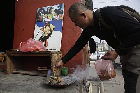 A family member lights incense in front of a photograph of Nepalese climber Min Bahadur Sherchan during his funeral in Kathmandu, Nepal, Sunday, May 7, 2017. (Photo|AP)