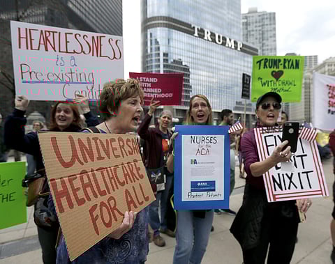 In this Friday, March 24, 2017, file photo, protesters gather across the Chicago River from Trump Tower to rally against the repeal of the Affordable Care Act, in Chicago. | AP