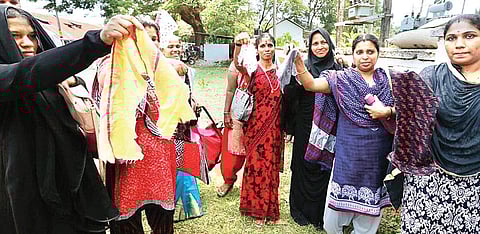 Parents display the chopped parts of the students' clothes at Kannur | Express