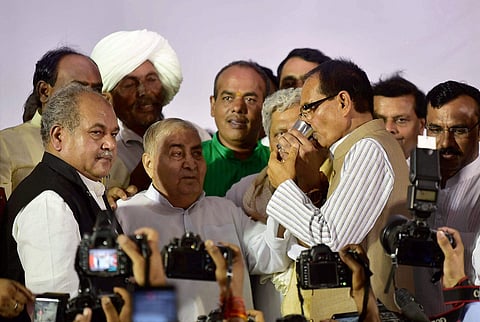 Madhya Pradesh Chief Minister Shivraj Singh Chouhan having juice from former Chief Minister Kailash Joshi to break his indefinite fast for Peace in State in Bhopal on Sunday. | File photo by PTI