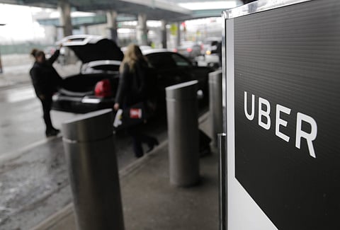 In this March 15, 2017, file photo, a sign marks a pick-up point for the Uber car service at LaGuardia Airport in New York. | AP