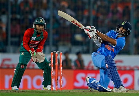 India’s Shikhar Dhawan plays a shot, as Bangladesh’s wicketkeeper Mushfiqur Rahim follows the ball during the Asia Cup Twenty20 international cricket final match between them in Dhaka, Bangladesh. |AP