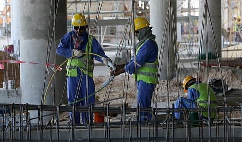 This file photo taken on October 03, 2013 shows migrant labourers working on a construction site on October 3, 2013 in Doha in Qatar. | AFP