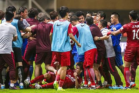 Shanghai SIPG players, red jersey, and Guangzhou R&F players, blue jersey, tussle after Shanghai's Oscar was tackled on the ground, during their Chinese Super League match in Guangzhou in south China's Guangdong province. | AP