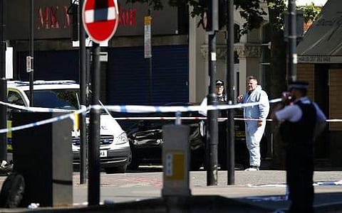 A forensic officer attends the scene where a van struck pedestrians in Finsbury Park, north London. | AP
