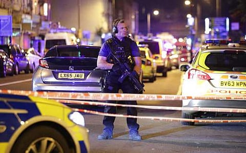 An armed police officer mans a cordon on the Seven Sisters Road at Finsbury Park where a vehicle struck pedestrians in London Monday, June 19, 2017. | AP