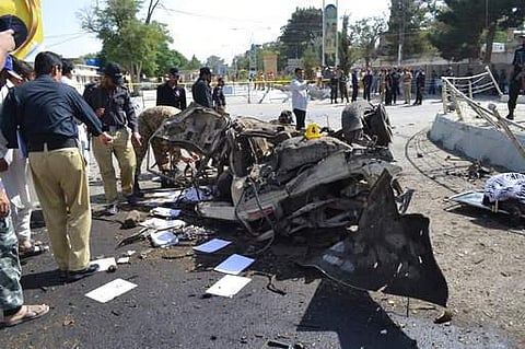 Pakistani police officers examine the site of an explosion in Quetta, Pakistan, Friday, June 23, 2017. A powerful bomb went off near the office of the provincial police chief in southwest Pakistan on Friday, causing casualties, police said. (AP Photo/Arsh