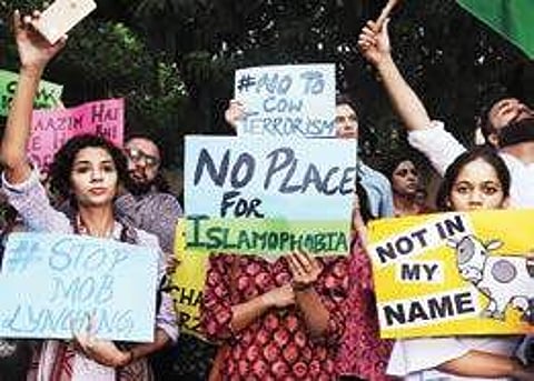 Protestors wave placards during a ‘Not in my name’ protest at Jantar Mantar, in New Delhi on Wednesday | pti