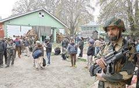 A soldier stands guard as people wait outside a government office near Lal Chowk in Srinagar | Sami ullah