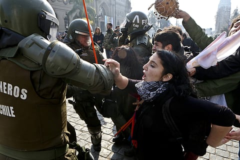 People protesting against of the self-proclaimed 'Bus of freedom,' which rejects transgender children in schools, clashes with police in downtown Santiago, Chile, Monday, July 10, 2017. (AP Photo/Esteban Felix)