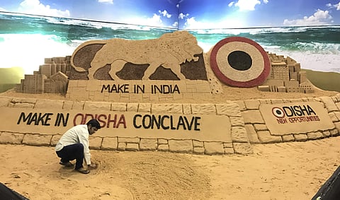 Artist Sudarsan Pattnaik creating a sand sculpture on Make in India Conclave at Janata Maidan. | Express