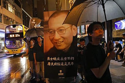 Protesters carry a picture of late Chinese Nobel Peace laureate Liu Xiaobo to mourn Liu near the Chinese liaison office in Hong Kong, Saturday, July 15, 2017. (AP Photo/Vincent Yu)