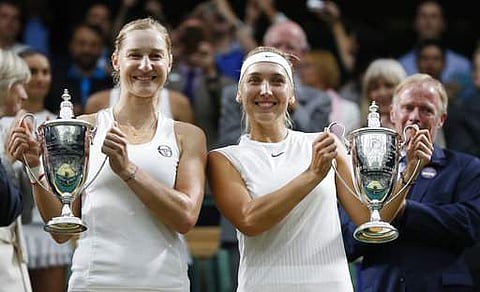 Elena Vesnina of Russia, right and her compatriot Ekaterina Makarova, hold up their winners trophies after they defeated Romania's Monica Niculescu, and Taiwan's Hao-Ching Chan to win the Women's Doubles final match on day twelve at the Wimbledon. | AP