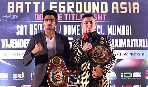 Indian boxing star and WBO Asia-Pacific Super Middleweight champion Vijender Singh (L) and his competitor WBO Oriental Super Middleweight champion China's Zulpikar Maimaitiali pose during a traditional face-off at a press conference in Mumbai. | AFP