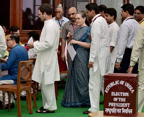 Congress president Sonia Gandhi with party Vice president Rahul Gandhi wait to cast vote in the Presidential Election in New Delhi on Monday. | PTI