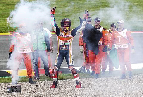 Moto GP rider Marc Marquez of Spain, center, celebrates with race track marshals after winning the German Motorcycle Grand Prix at the Sachsenring circuit in Hohenstein-Ernstthal, Germany, Sunday, July 2, 2017. | AP