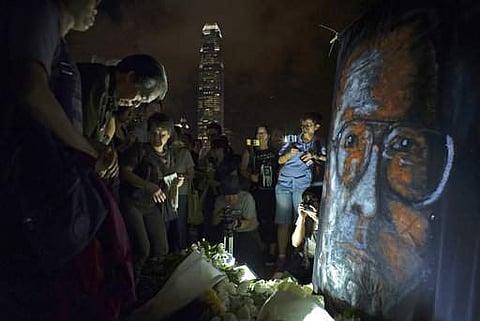 People pay tribute to late Chinese Nobel Peace laureate Liu Xiaobo at a downtown park against Victoria Habour in Hong Kong, Wednesday, July 19, 2017. (AP Photo/Vincent Yu)