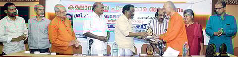 Cultural Affairs Minister A K Balan presenting the Kamala Surayya Award to T J S George, Editorial Adviser, The New Indian Express, in Thiruvananthapuram on Thursday. The award was instituted by Kamala Surayya Foundation and Friends Cultural Centre, Doha