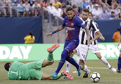 Barcelona's Neymar, center, attacks as Juventus goalkeeper Gianluigi Buffon, left, tries to block his shot during the first half of an International Champions Cup soccer match. (AP File photo)