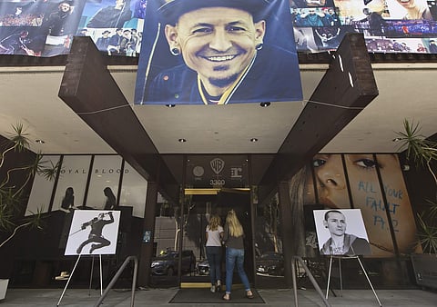 Banners showing photographs of singer Chester Bennington, the frontman for the rock band Linkin Park, are displayed on the front of the Warner Bros. Records offices in Burbank, Calif., Friday, July 21, 2017. | AP