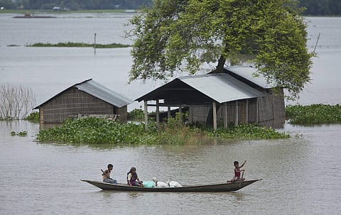An Indian boy rows a boat to cross flood waters at Burgaon, 80 kilometers (50 miles) east of Gauhati, Assam state, India, Wednesday, July 5, 2017. | AP