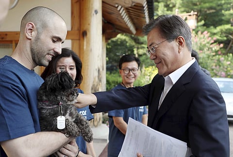 Photo provided by South Korean Presidential Blue House, South Korean President Moon Jae-in, right, touches the dog named Tory at the presidential Blue House in Seoul, South Korea. (Photo | AP)