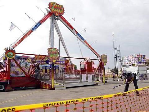 An Ohio State Highway Patrol trooper removes a ground spike from in front of the fire ball ride at the Ohio State Fair Thursday, July 27, 2017, in Columbus, Ohio. The fair opened Thursday but its amusement rides remained closed one day after Tyler Jarrell
