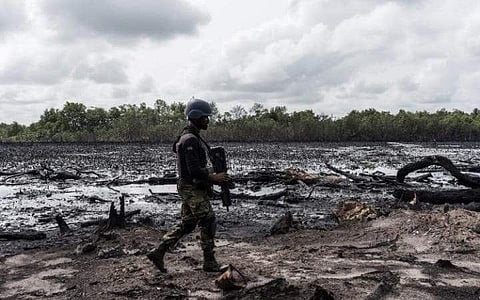 This file photo taken on April 19, 2017 shows a member of the Joint Task Force , Operation Delta Safe (OPDS), walking through an abandoned site of an illegal oil refinery in the Niger Delta region near the city of Warri (Photo: AFP)